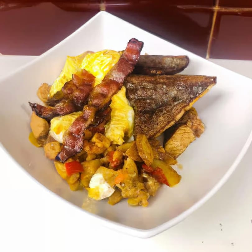 A breakfast plate from Waverly Deli with scrambled eggs, bacon, home fries, and toast.