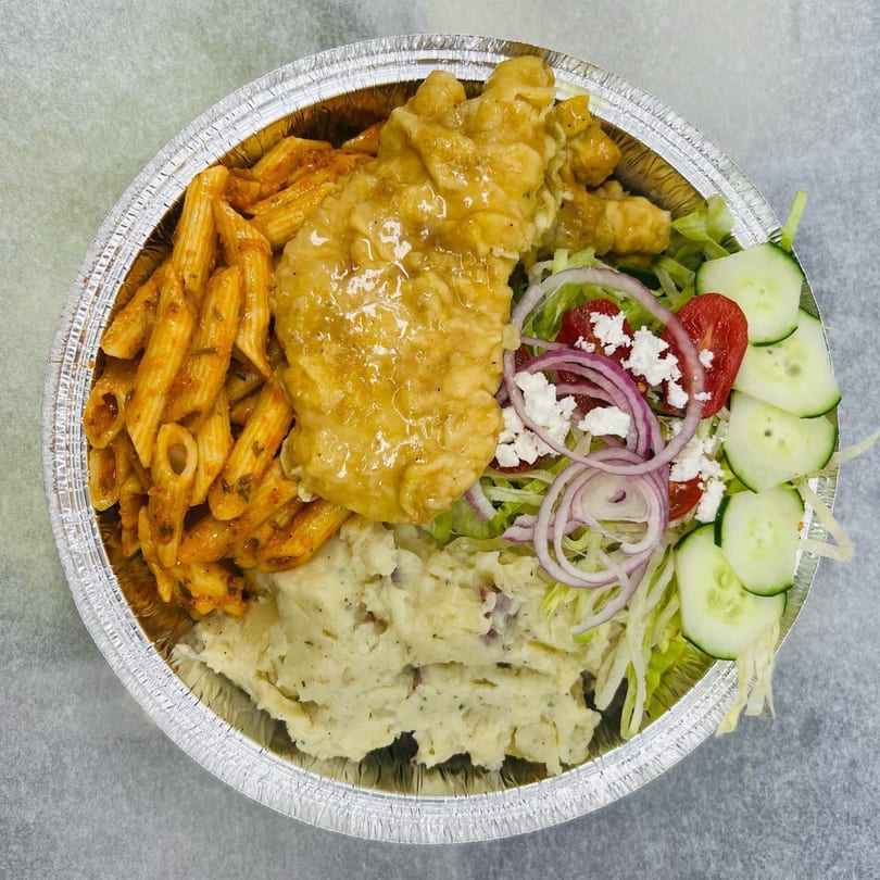 A Waverly Deli meal in a foil container with pasta, mashed potatoes, fried chicken, and salad.